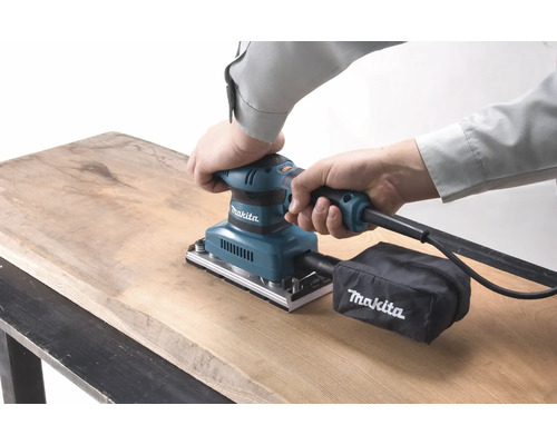 Makita Schwingschleifer in Gebrauch auf Holzoberfläche