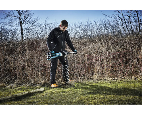Mann verwendet einen Erdbohrer im Freien.