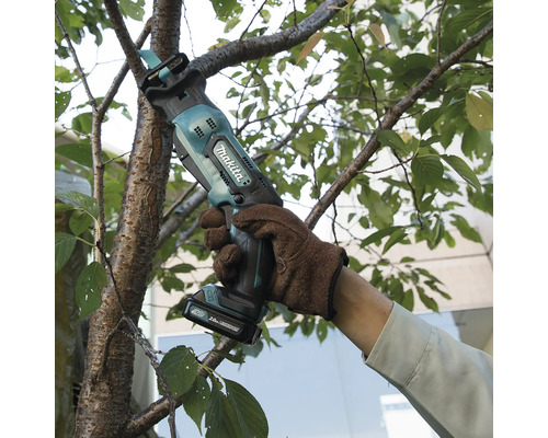 Eine Person schneidet mit einer Akku-Astsäge einen Baumast ab. Hersteller ist Makita.