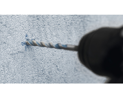 Nahaufnahme einer Bohrmaschine beim Bohren eines Lochs in eine Wand