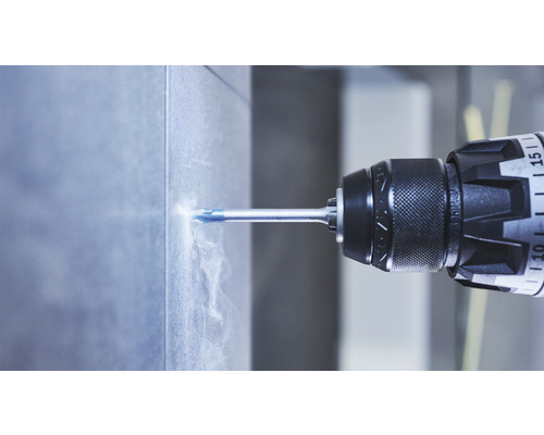 Eine Bohrmaschine bohrt ein Loch in eine Fliese.