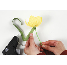 Person bastelt Papierblume mit Heißklebepistole