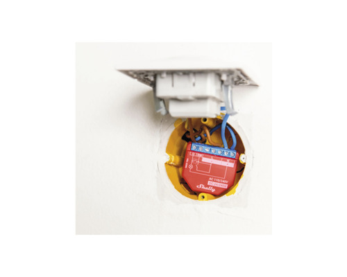 Eingebauter Smart Home Lichtschalter mit blauen Kabeln in gelber Wanddose