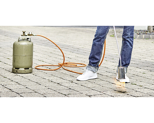 Unkrautbrenner mit Gasflasche im Einsatz auf Pflastersteinen