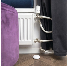 Heizkörperthermostat mit Heizkörper und Temperaturfühler auf Holzboden