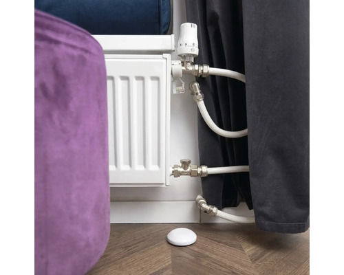 Heizkörperthermostat mit Heizkörper und Temperaturfühler auf Holzboden