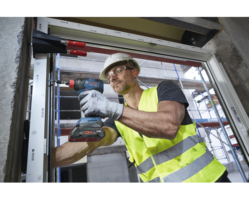 Handwerker montiert Fenster mit einem Akku-Schlagschrauber