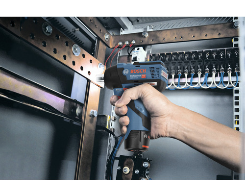 Hand hält einen Bosch Akku-Drehschlagschrauber vor einem Schaltschrank.