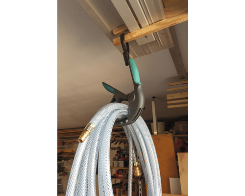 Ein transparenter Wasserschlauch hängt an einer Klemme zur Aufbewahrung.