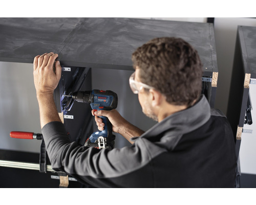 Handwerker arbeitet mit einem Akkuschrauber an einem Möbelstück