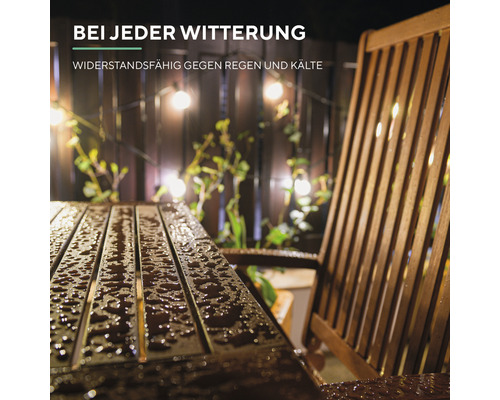 Gartenszene mit Holzmöbeln und Lichterkette bei Regenwetter