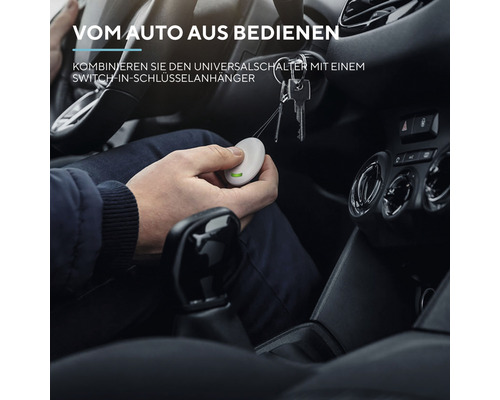 Person bedient Universal Schalter im Auto mit Schlüsselanhänger