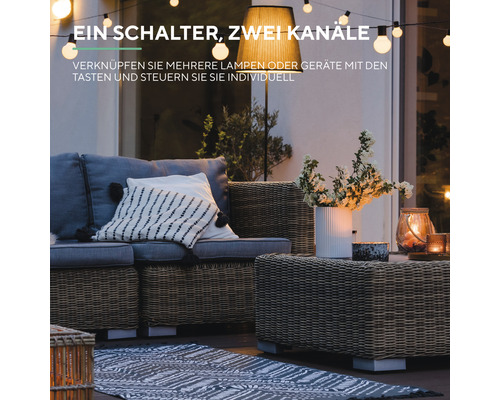 Dekorativer Außenbereich mit Rattansitzgruppe, Stehlampe und Lichterkette