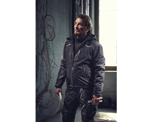 Handwerker trägt Arbeitskleidung mit Jacke und Hose