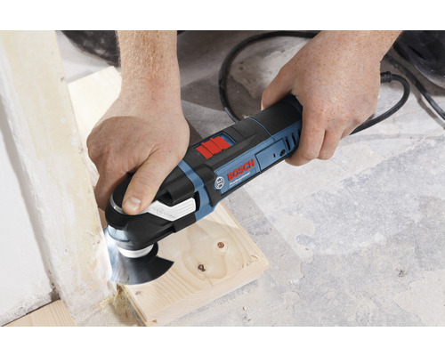 Eine Person verwendet ein Bosch Multifunktionswerkzeug zum Bearbeiten von Holz.