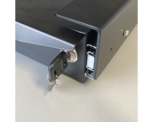 Detailansicht eines Schlüssels im Schloss einer schwarzen Kassette