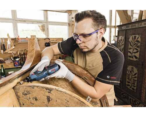 Mann schleift Holz mit einem Multifunktionswerkzeug von Bosch