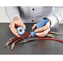 Person lötet Kabel mit Lötkolben und Lötzinn