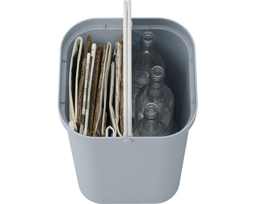 Abfallbehälter gefüllt mit Altpapier und leeren Glasflaschen