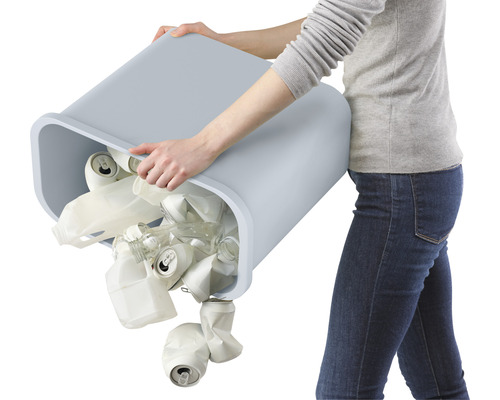 Eine Person leert einen Abfallbehälter gefüllt mit Dosen, Plastik und Glas.