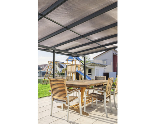 Terrasse mit Terrassenüberdachung, Holztisch und Stühlen im Garten.