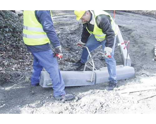 Zwei Bauarbeiter setzen Bordsteine mit einem Bordsteinversetzgerät.