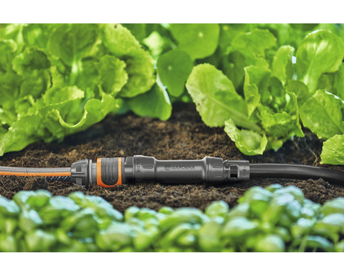 Gardena Verbindungsstück mit zwei Gartenschläuchen im Beet