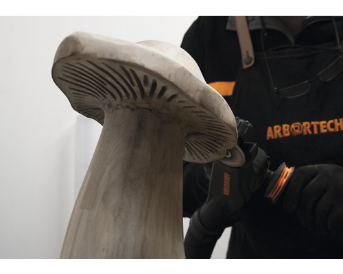 Person bearbeitet Holzpilz mit einer ArborTech Holzbearbeitungsmaschine