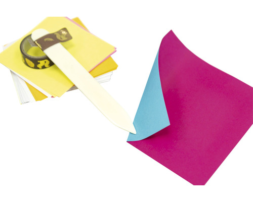 Bastelmaterial mit Papier, Falzbein und Dekoband