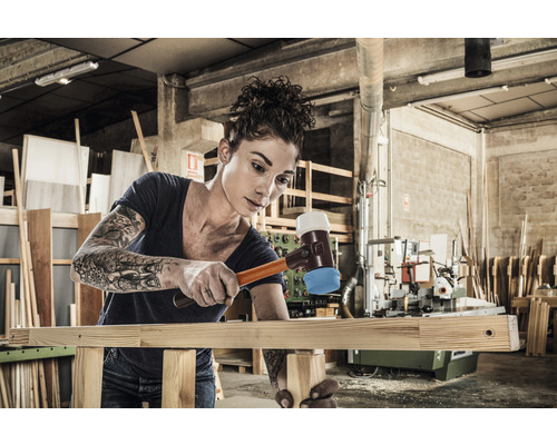 Frau benutzt Schonhammer in Werkstatt zum Holzbearbeiten