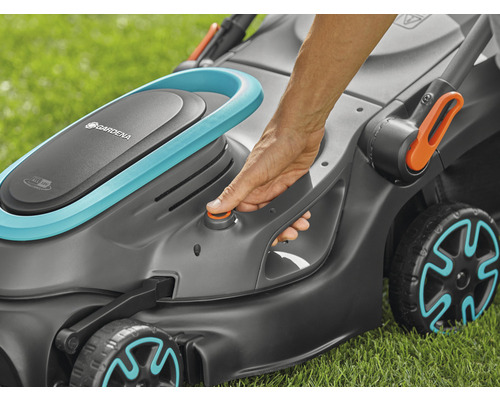 Nahaufnahme eines Gardena Rasenmähers mit einer Hand, die einen Knopf drückt