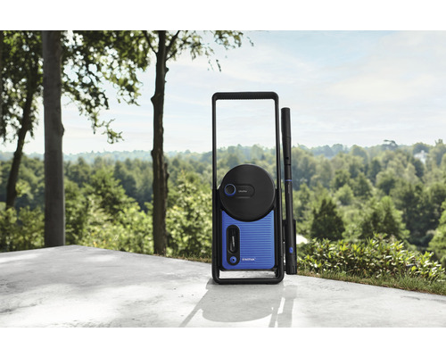 Nilfisk Hochdruckreiniger auf einer Terrasse mit Baumkulisse