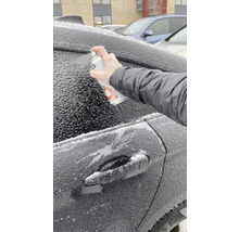 Eine Person sprüht Enteisungsspray auf ein vereistes Auto.