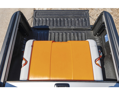 Orangefarbene Transportbox auf der Ladefläche eines Pick-up-Trucks.