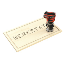 Einhell Akku-Oberfräse beim Fräsen des Wortes Werkstatt in ein Holzschild