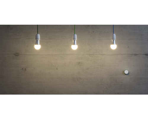 Drei LED-Lampen hängen vor einer Betonwand.