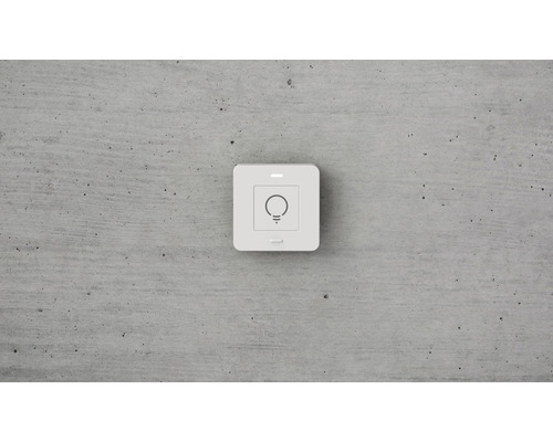 Quadratischer Lichtschalter mit Lampensymbol an der Wand