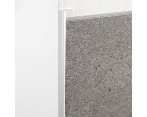 Detailansicht einer weißen Fliesenschiene an einer Wand und Fliese