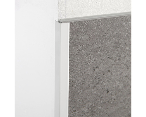 Detailansicht einer weißen Fliesenschiene aus Kunststoff an einer Wand