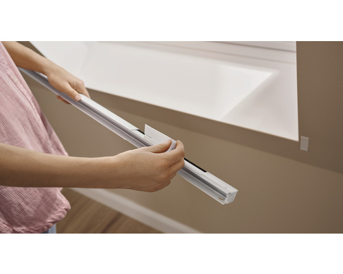 Person montiert ein Dachfenster-Rollo