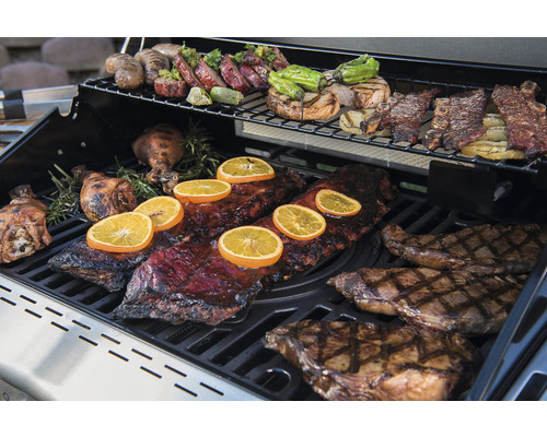 Grill mit verschiedenen Speisen wie Rippchen, Steak und Gemüse.