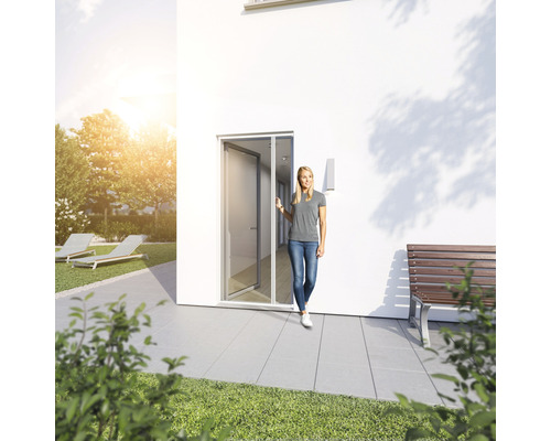 Frau betritt Haus durch Tür mit Insektenschutzgitter.