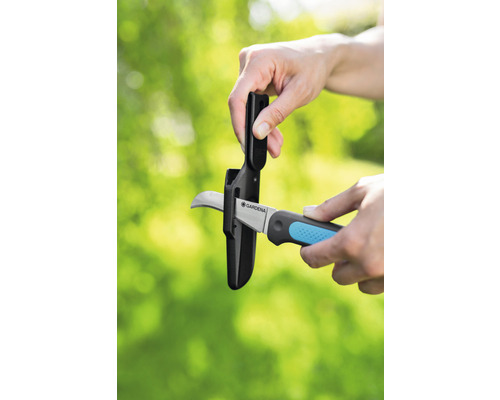 Gartenschere mit Klingenschutz wird in Schutzhülle gesteckt