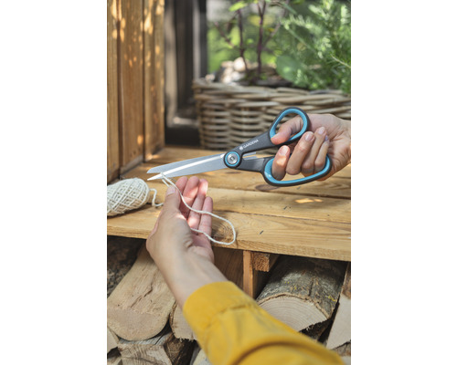 Eine Person schneidet eine Schnur mit einer Gartenschere von Gardena.