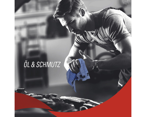 Mann reinigt mit einem Putzlappen einen Motor von Öl und Schmutz