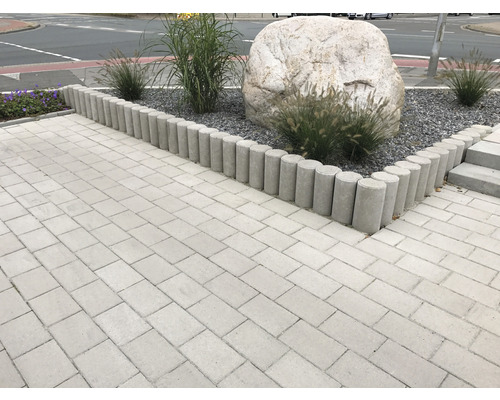 Gestalteter Außenbereich mit Pflastersteinen, Rasenkanten und Pflanzen