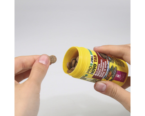 JBL Novo Tab food tablets for all fish species being poured from a yellow container