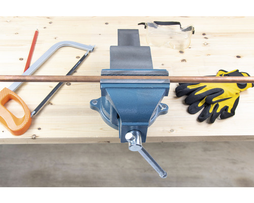 Werkbank mit Schraubstock, Kupferrohr, Säge, Schutzbrille und Handschuhen