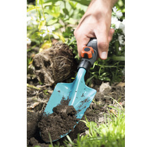 Gartenszene mit Hand und Pflanzschaufel im Erdreich