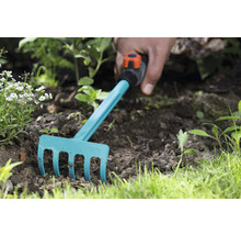Gartenrechen im Einsatz im Beet